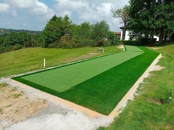 Flagstaff Outdoor tee line consisting of one continuous green synthetic grass strip surrounded by trees